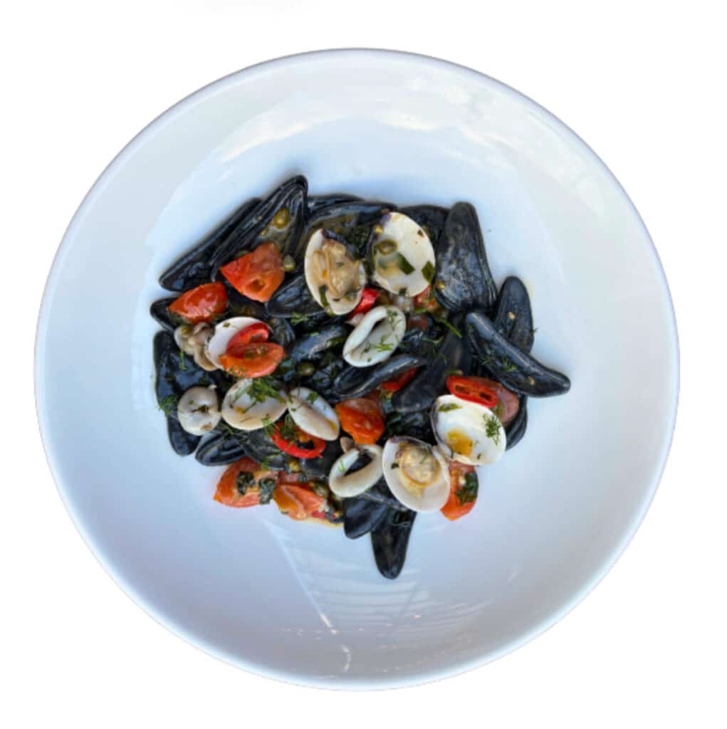 Handcrafted black strascinate pasta served with prawns, mussels, and fresh herbs in a seafood reduction.