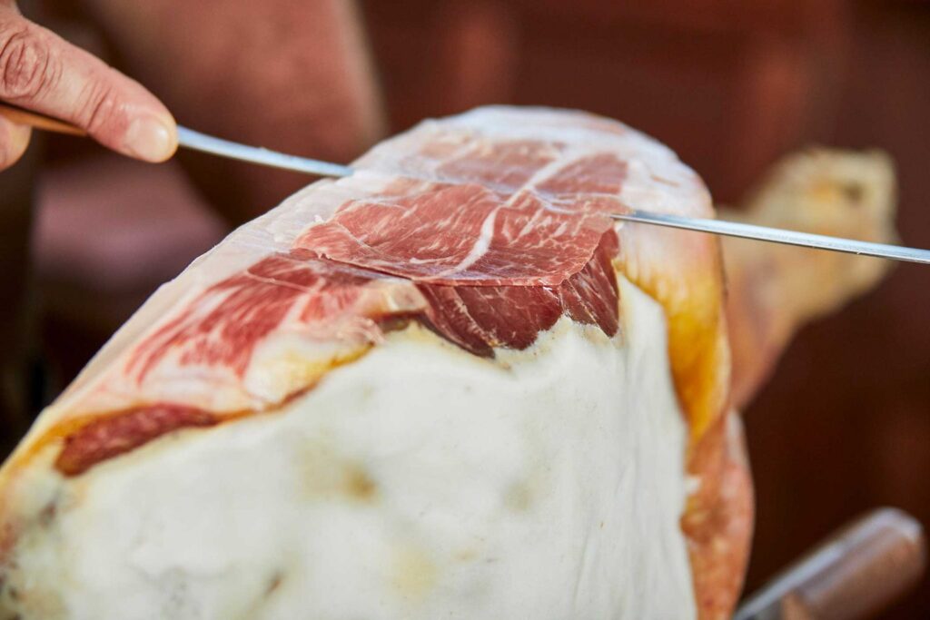 Hand slicing Italian prosciutto from the leg, supplied by MOCO Food Services in Brisbane